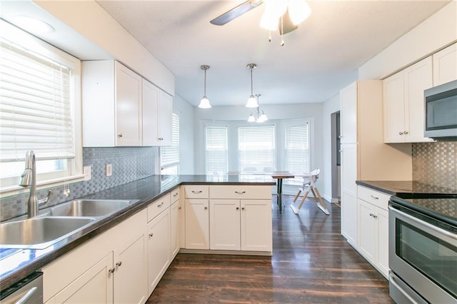 308 Acorn Pl, Warrensburg, MO 64093 - kitchen with appliances with stainless steel finishes, dark wood-style floors, hanging light fixtures, and dark countertops