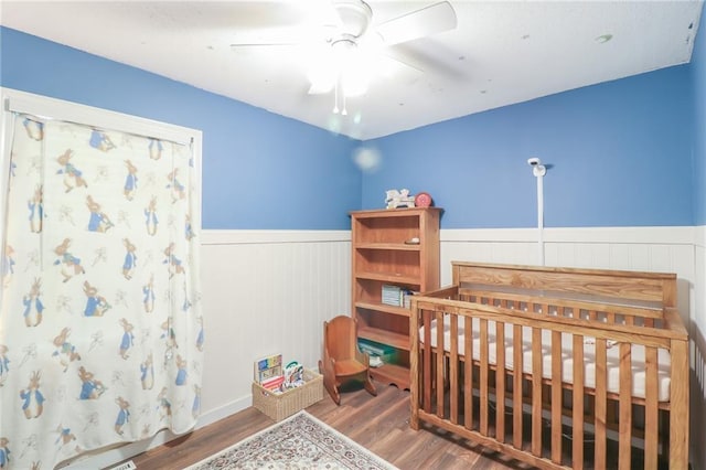 308 Acorn Pl, Warrensburg, MO 64093 - bedroom with wainscoting, wood finished floors, and a ceiling fan