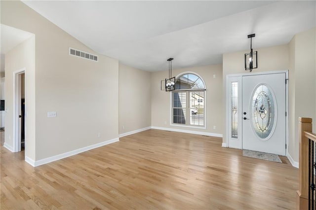 foyer entrance with a notable chandelier, baseboards, visible vents, and light wood-type flooring