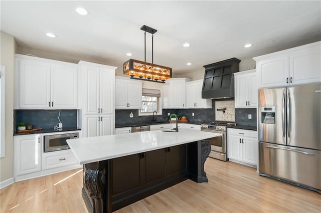 kitchen with light wood-style flooring, white cabinets, and stainless steel appliances