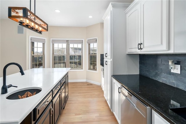 kitchen with a sink, dishwasher, white cabinets, and light wood finished floors