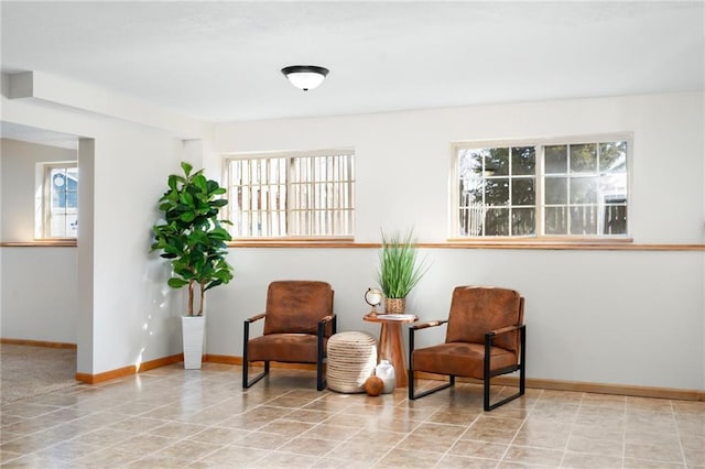 sitting room with a wealth of natural light, tile patterned floors, and baseboards