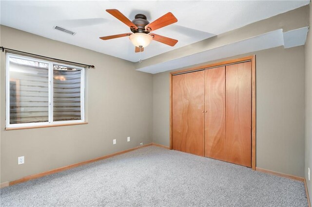 unfurnished bedroom with visible vents, a ceiling fan, a closet, carpet, and baseboards