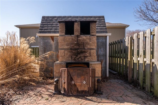 exterior space featuring exterior fireplace and fence