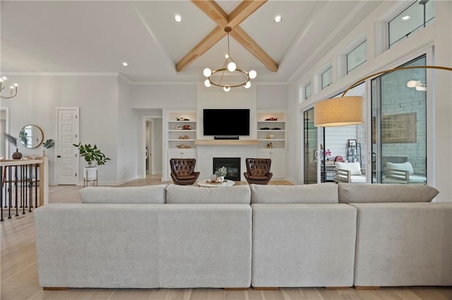 12313 W 169th St, Overland Park, KS 66221 - living room with a chandelier, a glass covered fireplace, a towering ceiling, beam ceiling, and built in shelves