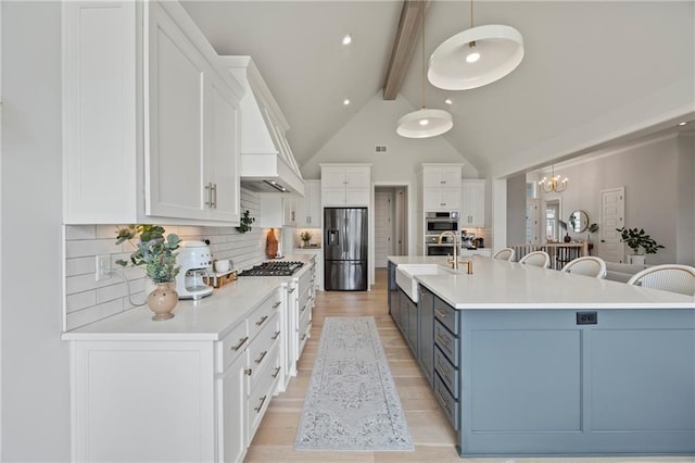 12313 W 169th St, Overland Park, KS 66221 - kitchen with stainless steel appliances, beamed ceiling, light countertops, white cabinets, and tasteful backsplash