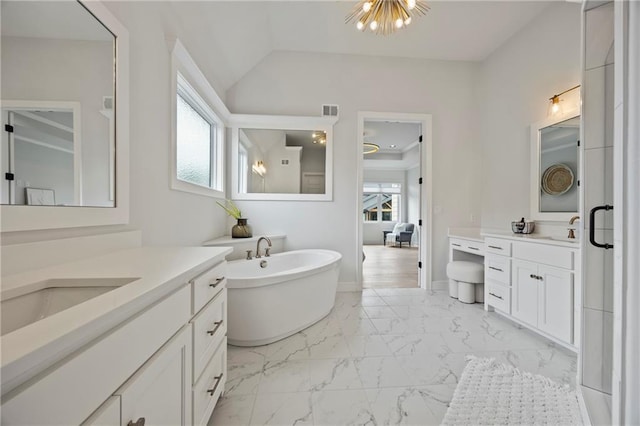 12313 W 169th St, Overland Park, KS 66221 - full bathroom featuring marble look tile flooring, two vanities, a freestanding bath, and vaulted ceiling