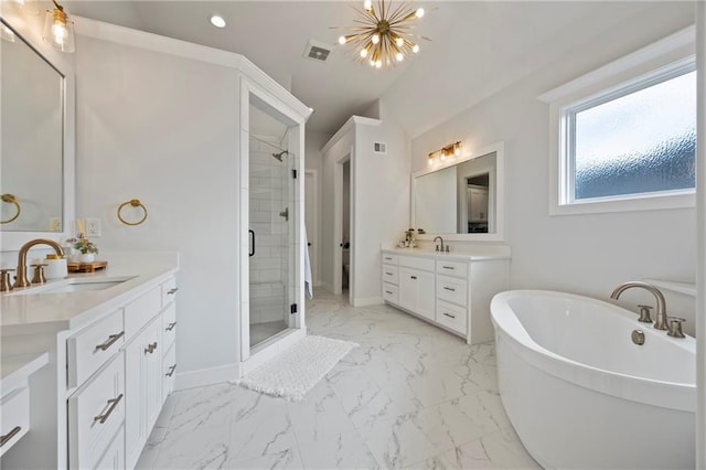 12313 W 169th St, Overland Park, KS 66221 - full bathroom featuring marble look tile flooring, a shower stall, two vanities, a freestanding tub, and a chandelier