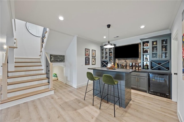 12313 W 169th St, Overland Park, KS 66221 - indoor wet bar featuring beverage cooler, decorative backsplash, light wood-style floors, stairs, and recessed lighting