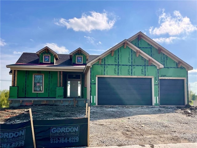 property in mid-construction with a porch, an attached garage, driveway, and roof with shingles