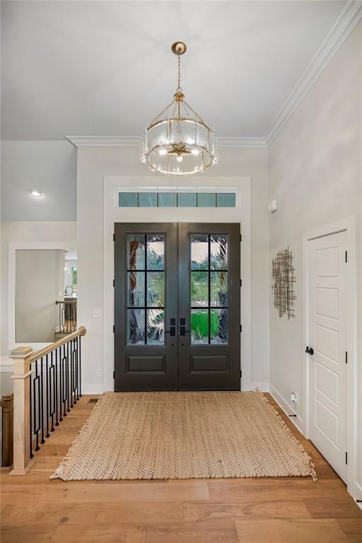 13021 W 174th Pl, Overland Park, KS 66221 - entryway featuring a chandelier, french doors, ornamental molding, wood finished floors, and baseboards