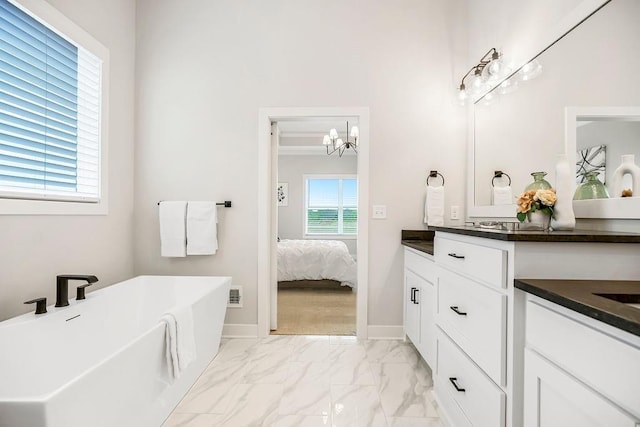 13021 W 174th Pl, Overland Park, KS 66221 - ensuite bathroom with vanity, a chandelier, a soaking tub, marble look tiles, and baseboards