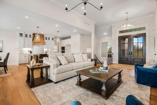 13021 W 174th Pl, Overland Park, KS 66221 - living room featuring light wood finished floors, a chandelier, ornamental molding, french doors, and recessed lighting