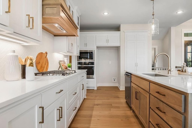 13021 W 174th Pl, Overland Park, KS 66221 - kitchen with stainless steel appliances, a sink, custom exhaust hood, white cabinets, and hanging light fixtures