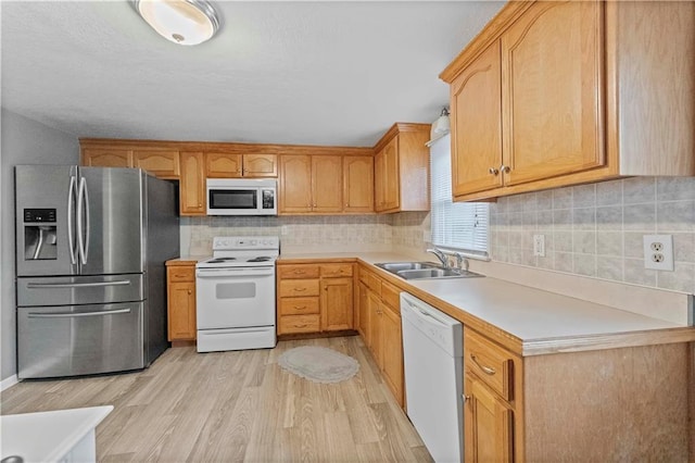 607 SW 8th St, Blue Springs, MO 64015 - kitchen featuring tasteful backsplash, light countertops, light wood-type flooring, white appliances, and a sink