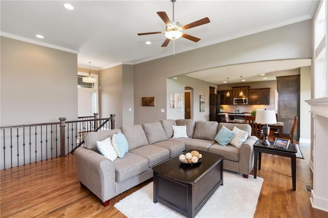 16487 W 166th Pl, Olathe, KS 66062 - living area with light wood finished floors, recessed lighting, ceiling fan, crown molding, and arched walkways