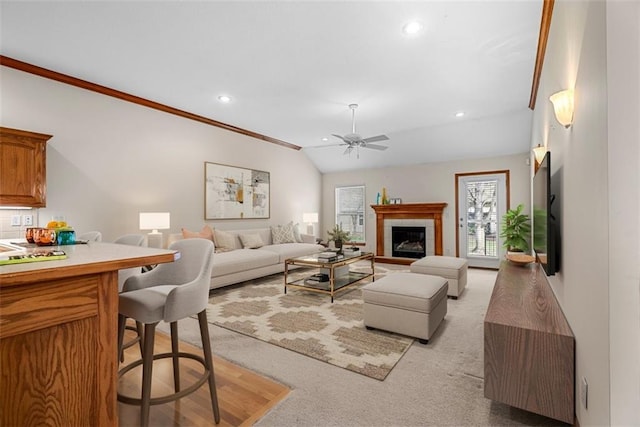living area with lofted ceiling, recessed lighting, light carpet, a ceiling fan, and a tile fireplace