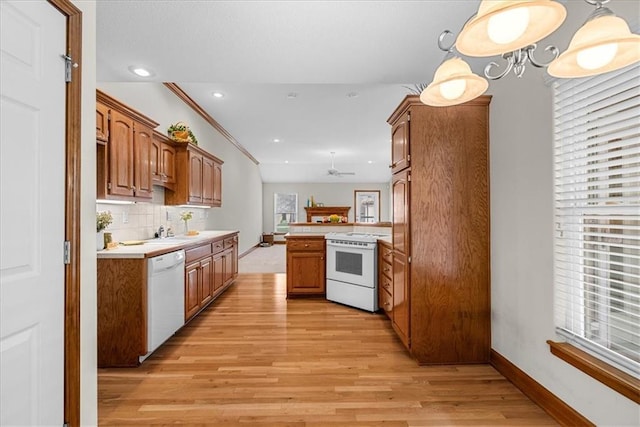 kitchen with white appliances, light countertops, brown cabinets, and a peninsula