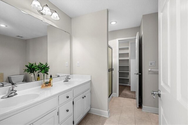 full bath with tile patterned floors, a sink, a stall shower, and baseboards