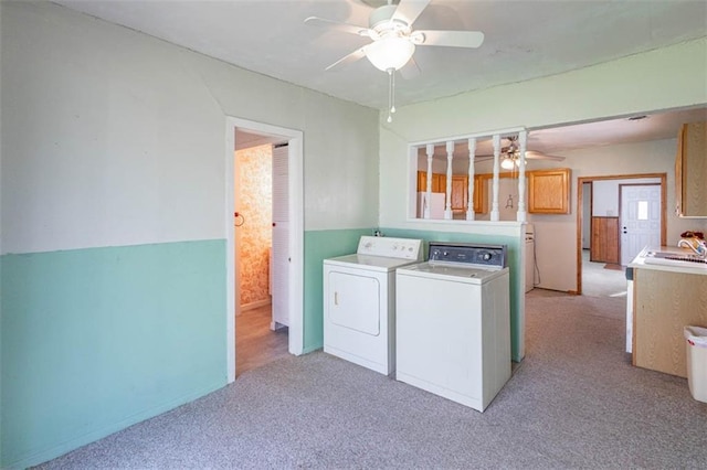 laundry room with washing machine and clothes dryer, a sink, a ceiling fan, light carpet, and laundry area