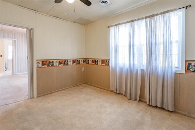 empty room with carpet, ceiling fan, and visible vents