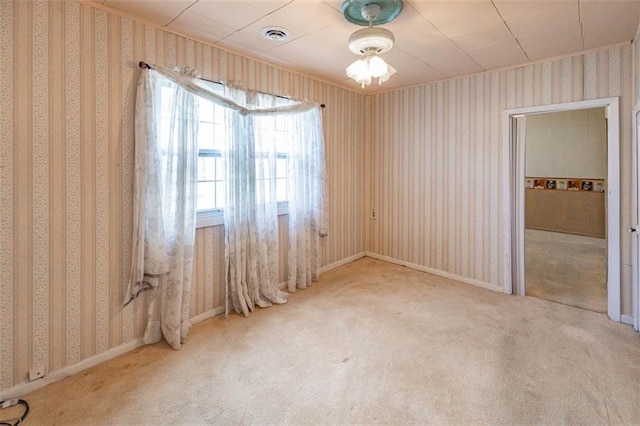 empty room featuring baseboards, carpet flooring, visible vents, and wallpapered walls