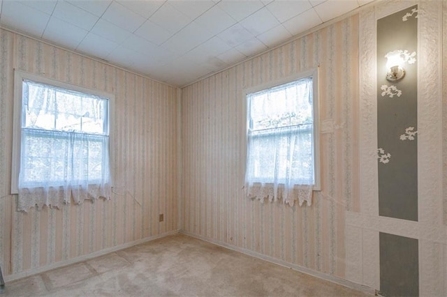 unfurnished room featuring wallpapered walls and a healthy amount of sunlight
