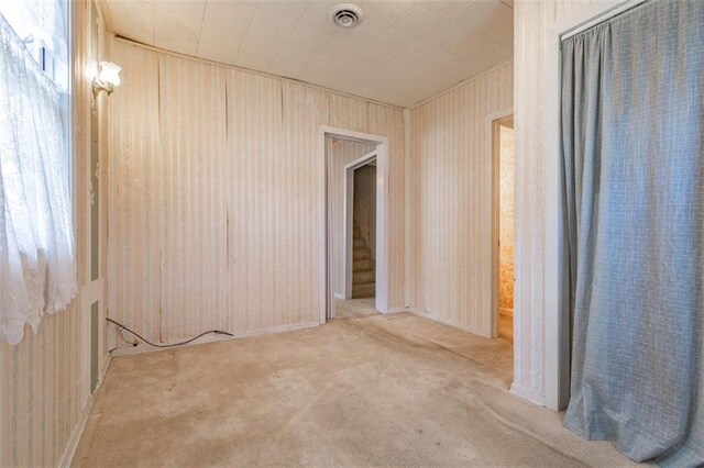 carpeted spare room featuring visible vents