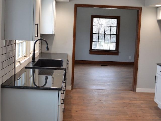 660 Elmdale, Chillicothe, MO 64601 - kitchen with dark countertops, white cabinets, wood finished floors, and a sink