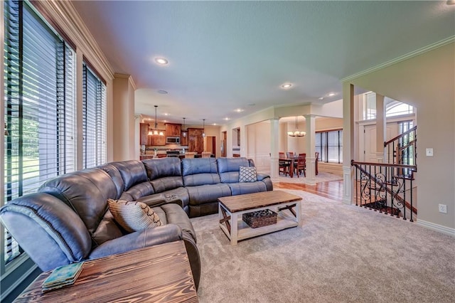 living room featuring a chandelier, decorative columns, ornamental molding, recessed lighting, and light colored carpet