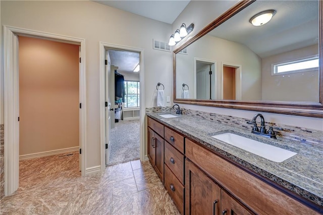full bathroom featuring lofted ceiling, double vanity, and baseboards