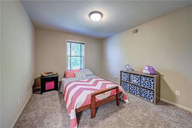 bedroom featuring carpet floors, baseboards, and a textured ceiling