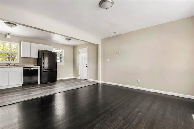 1758 Main St, Osawatomie, KS 66064 - kitchen with white cabinetry, baseboards, open floor plan, wood finished floors, and black appliances