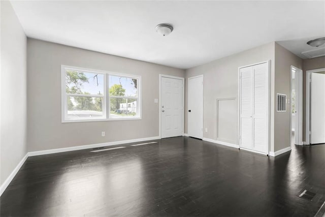 1758 Main St, Osawatomie, KS 66064 - unfurnished living room featuring baseboards, dark wood finished floors, and visible vents