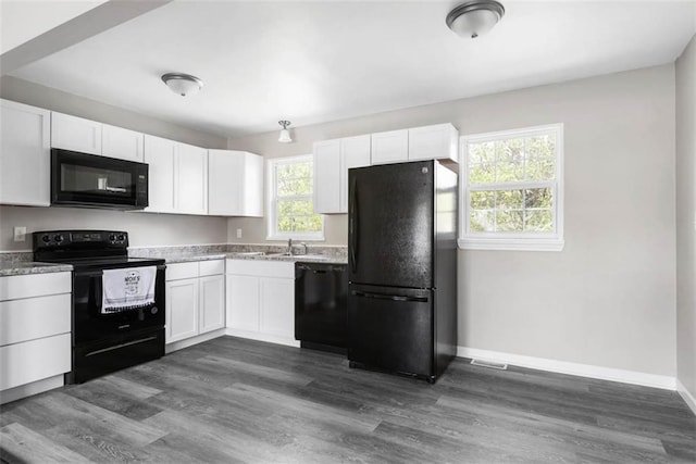 1758 Main St, Osawatomie, KS 66064 - kitchen with baseboards, black appliances, white cabinetry, and visible vents