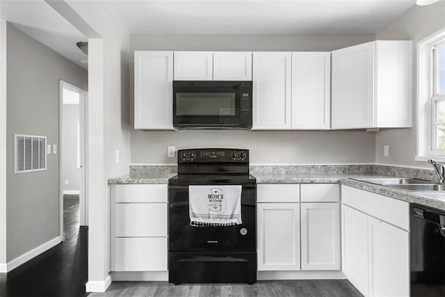 1758 Main St, Osawatomie, KS 66064 - kitchen featuring white cabinets, black appliances, and dark wood-style floors