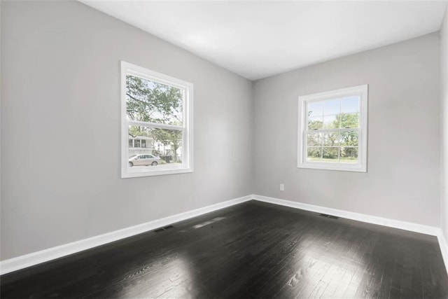 1758 Main St, Osawatomie, KS 66064 - empty room featuring a healthy amount of sunlight, baseboards, and dark wood finished floors