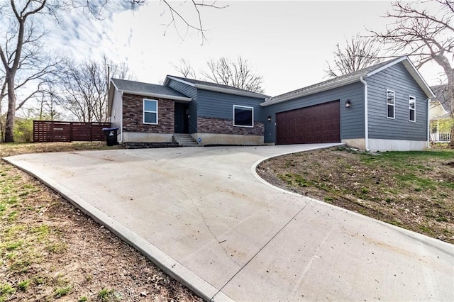 view of front facade with stone siding, an attached garage, and concrete driveway