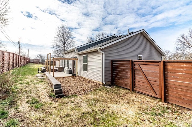 rear view of property with a fenced backyard, a gate, and a patio area