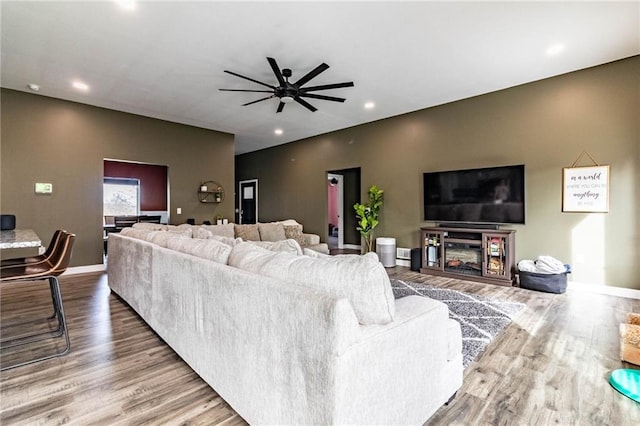 living area featuring baseboards, wood finished floors, recessed lighting, and a ceiling fan