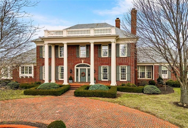17960 S Bond St, Bucyrus, KS 66013 - neoclassical / greek revival house with a balcony, brick siding, a chimney, and a front yard