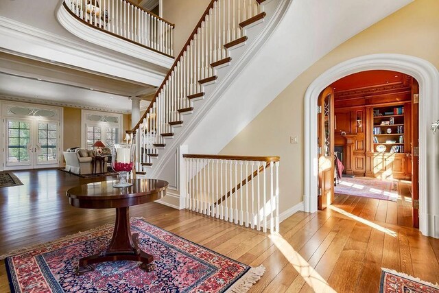 17960 S Bond St, Bucyrus, KS 66013 - entrance foyer featuring hardwood / wood-style floors, arched walkways, french doors, stairs, and ornamental molding