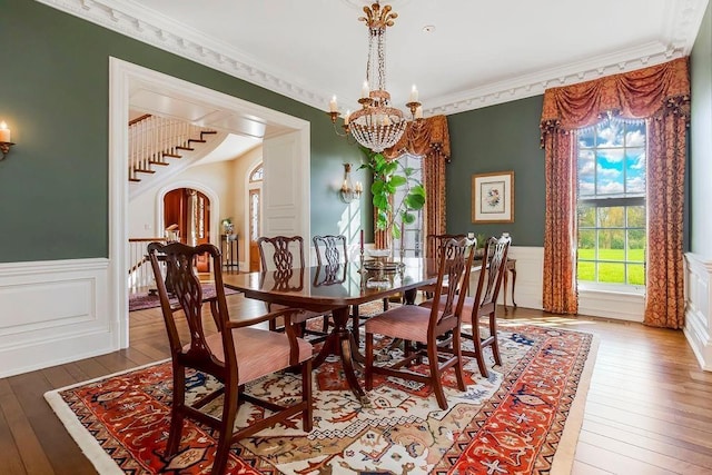 17960 S Bond St, Bucyrus, KS 66013 - dining area with a chandelier, wainscoting, hardwood / wood-style floors, arched walkways, and ornamental molding