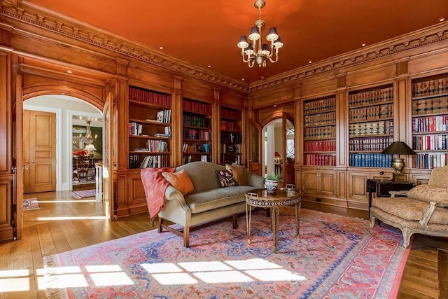 17960 S Bond St, Bucyrus, KS 66013 - sitting room featuring built in features, crown molding, arched walkways, hardwood / wood-style flooring, and a chandelier