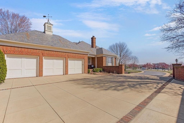 17960 S Bond St, Bucyrus, KS 66013 - view of front facade with brick siding, driveway, a garage, and a chimney