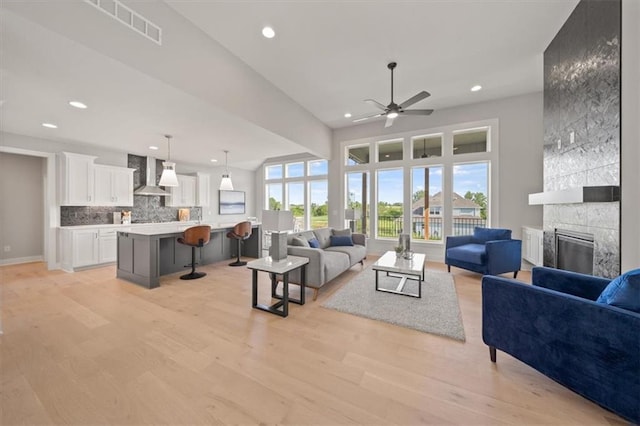 4275 Lake Shore Ct, Basehor, KS 66007 - living room with a ceiling fan, light wood-style floors, a large fireplace, recessed lighting, and baseboards
