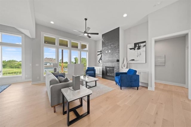 4275 Lake Shore Ct, Basehor, KS 66007 - living room featuring a fireplace, ceiling fan, light wood-style flooring, recessed lighting, and baseboards