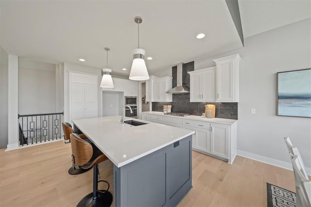 4275 Lake Shore Ct, Basehor, KS 66007 - kitchen featuring a sink, wall chimney range hood, light wood finished floors, tasteful backsplash, and recessed lighting