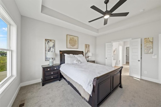 4275 Lake Shore Ct, Basehor, KS 66007 - bedroom with light colored carpet, a tray ceiling, baseboards, and ceiling fan