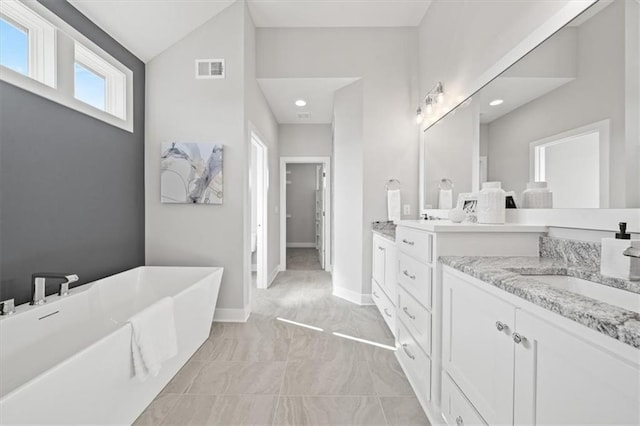4275 Lake Shore Ct, Basehor, KS 66007 - full bath with vanity, a freestanding tub, vaulted ceiling, marble finish flooring, and baseboards